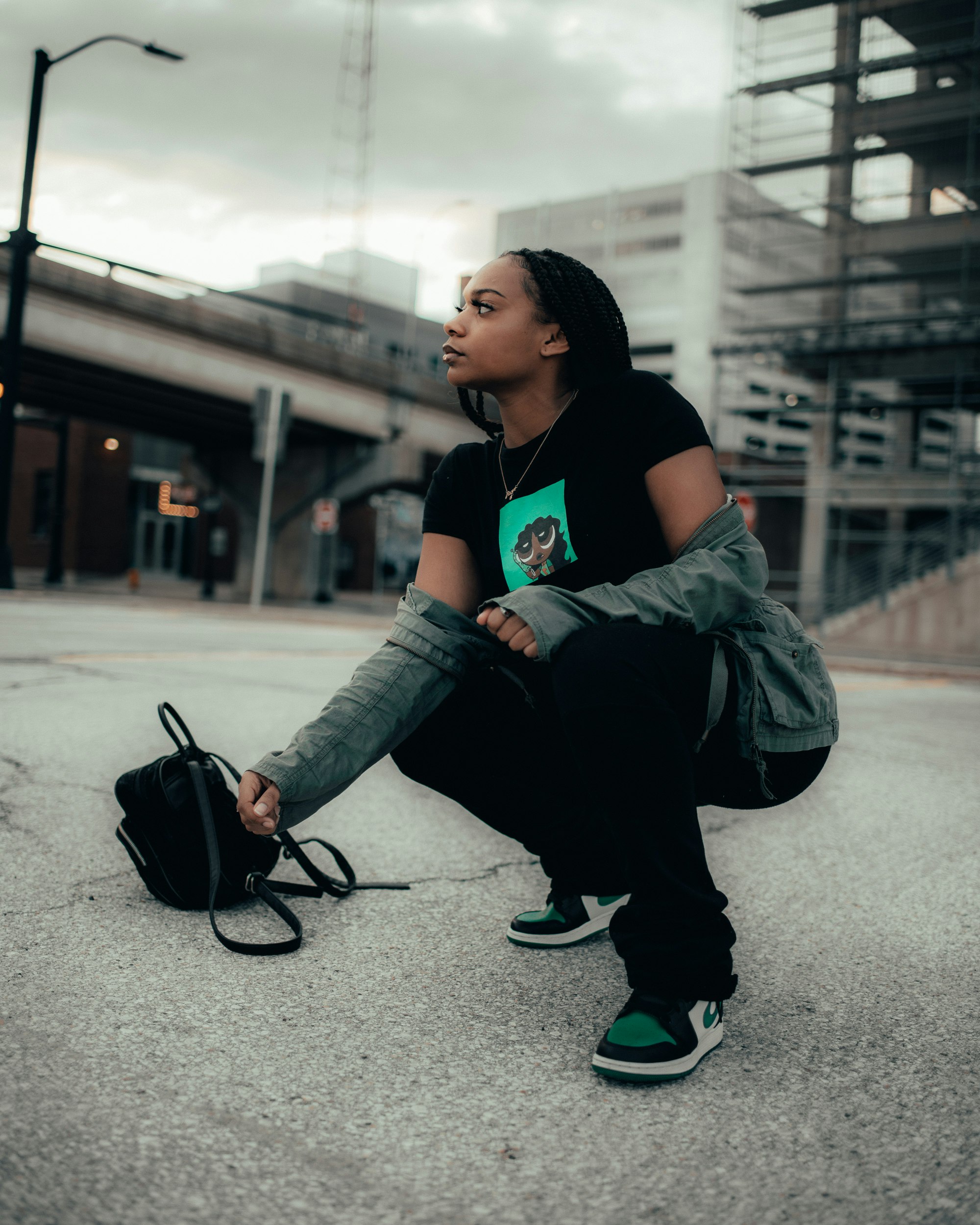 woman in blue denim jeans and green nike athletic shoes sitting on gray concrete floor during